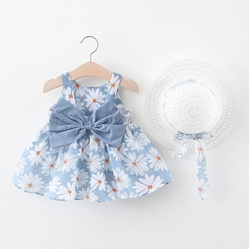 A light blue floral baby girl summer dress with a bow and a white woven sunhat