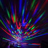 A close-up shot of a starry night light projector casting colorful, swirling light patterns onto a surface.