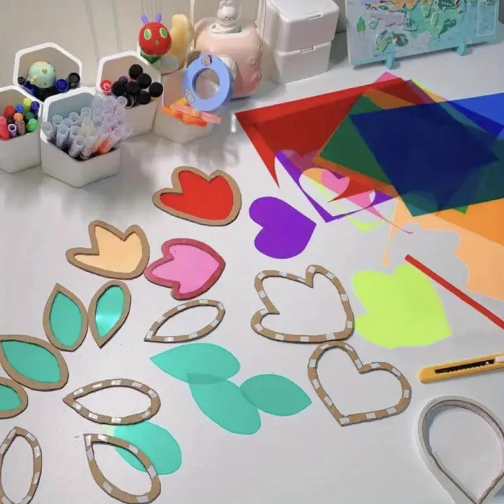 A collection of transparent colored PVC sheets, including hearts, leaves, and shapes, laid out on a white surface.