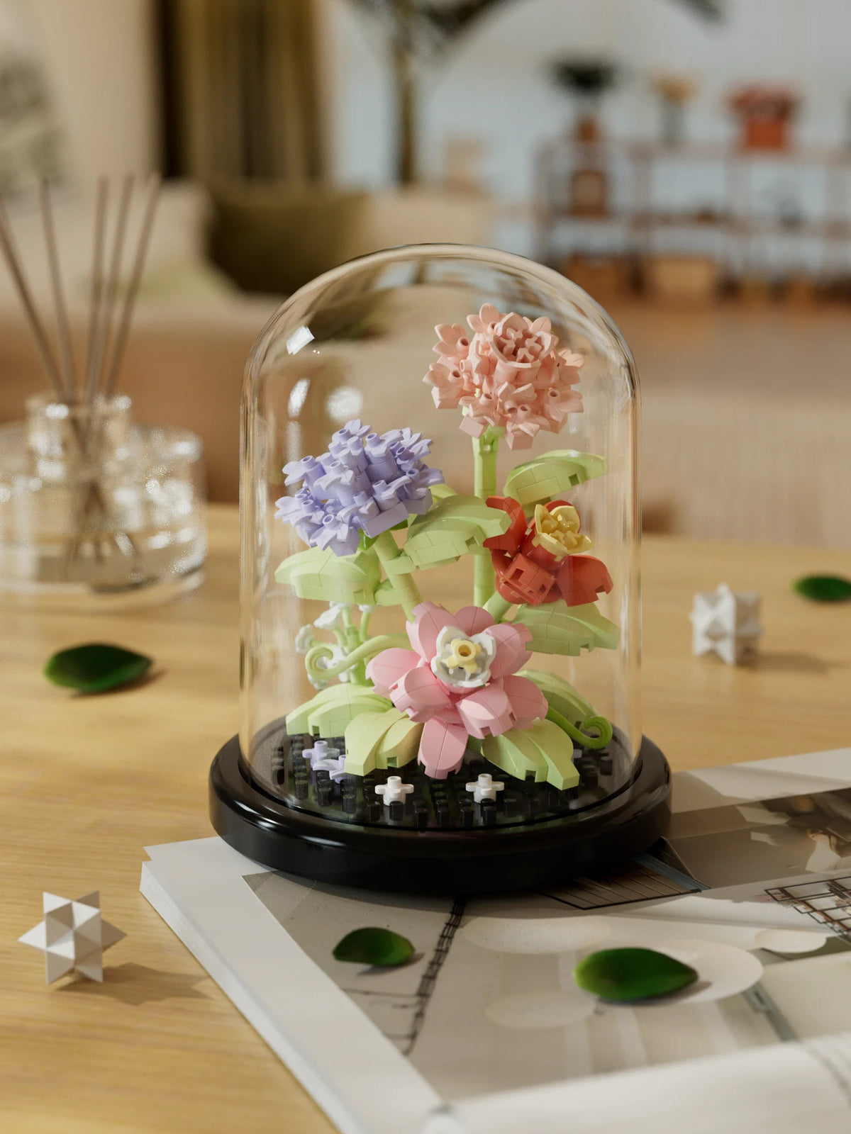 A glass dome display featuring a miniature floral arrangement of pink and purple roses on a dark base.