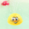 A yellow, smiling bath toy is being sprayed with water, with a red object visible in the background.