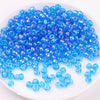 A pile of small, round blue glass beads for DIY jewelry and crafting.