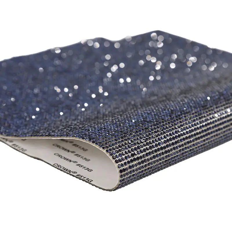 Blue sparkling rhinestone adhesive tape rolled up, showing a textured surface and brand markings.