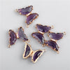 A set of purple crystal butterfly charm beads used for jewelry making.