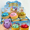 A hand holds a purple glitter dumpling squishy toy next to its packaging and other colorful squishies.