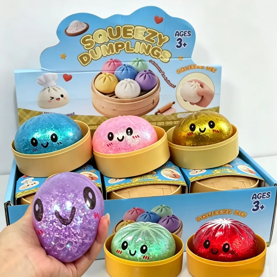 A hand holds a purple glitter dumpling squishy toy next to its packaging and other colorful squishies.