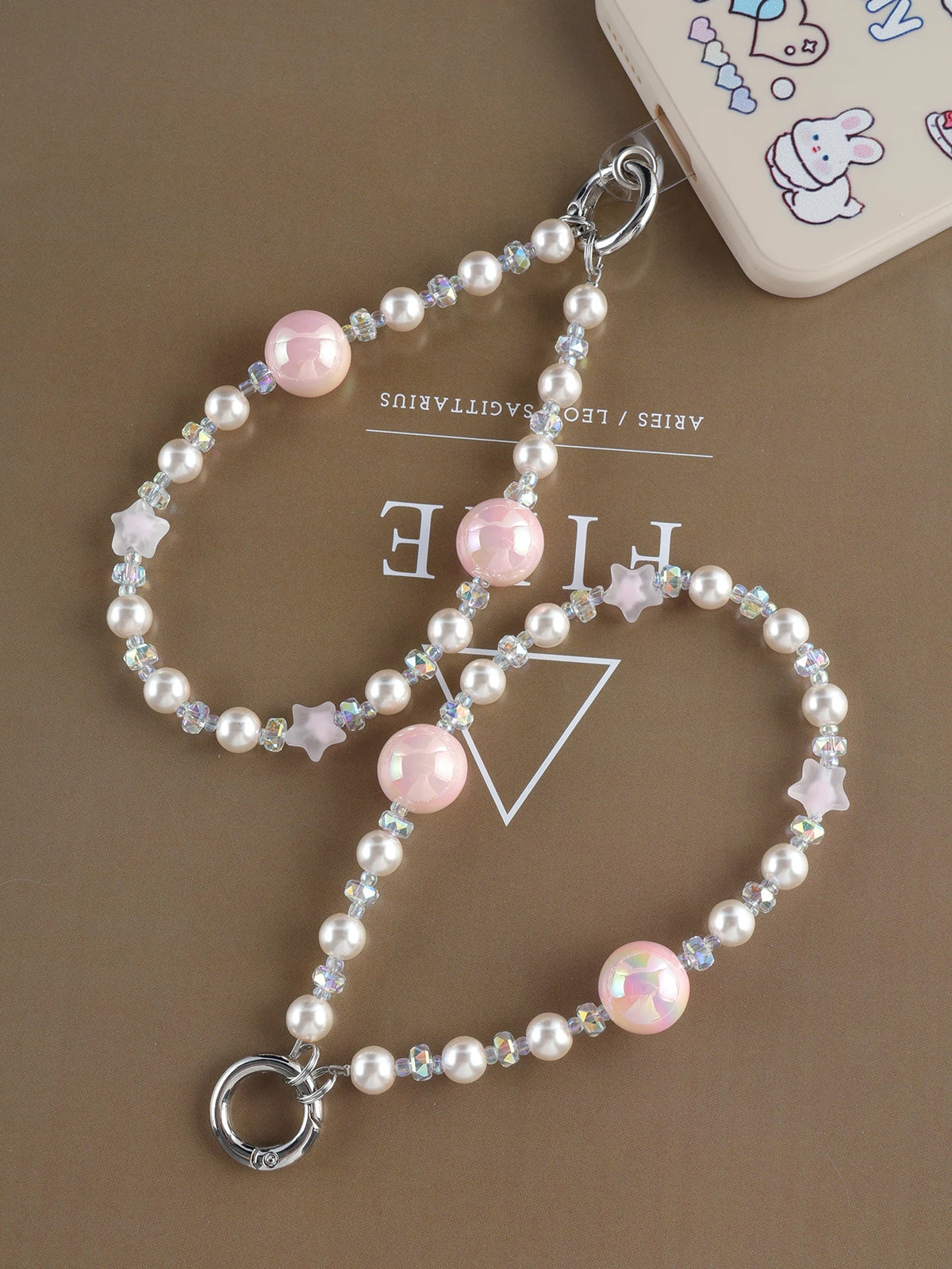 A delicate pearl crystal necklace featuring pink and clear stones with a star charm and bag clip.