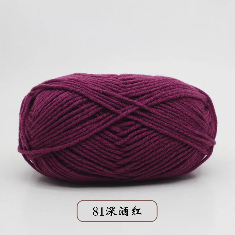 A ball of deep magenta pre-dyed milk cotton yarn used for knitting and crochet.