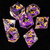 A collection of translucent purple and yellow liquid core dice, including d4s, d8s, d10s, d12s, and d20s.