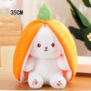 A white plush bunny toy is nestled inside an orange fruit-shaped fabric, resembling a pumpkin or citrus fruit.