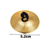 A round brass or gold-colored percussion instrument with a black loop, likely a mini copper finger cymbal.