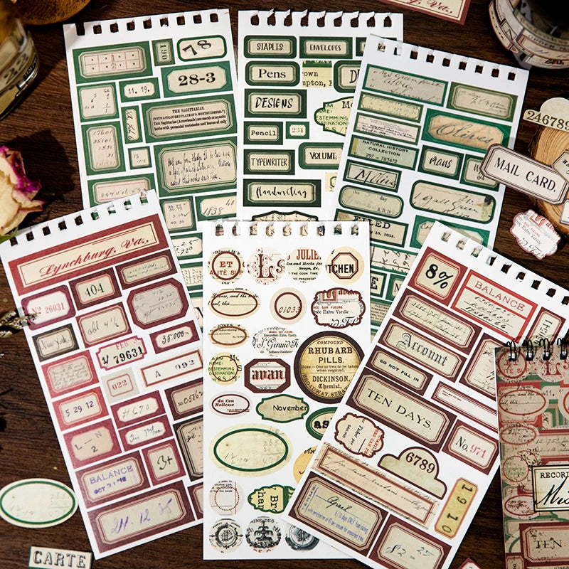 A collection of vintage label stickers and stamps for scrapbooking and journaling displayed on a wooden surface.