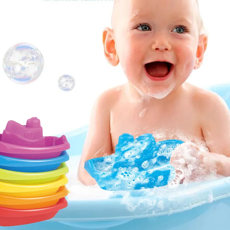 A baby is playing with blue bath toys and floating bubbles in a blue tub.