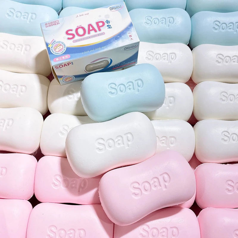 A collection of various soft, squishy soap balls in pastel colors including white, light blue, pink, and peach.