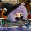 A purple fluffy witch hat plush blind box featuring a face and black trim, displayed on a patterned surface.