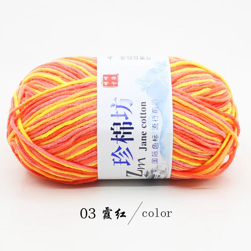 A ball of bright orange and yellow yarn labeled as Zinc Jane cotton yarn for knitting and crochet