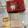 A red carrying case for a classic Chinese Mahjong set with 144 tiles and a separate set of tiles.