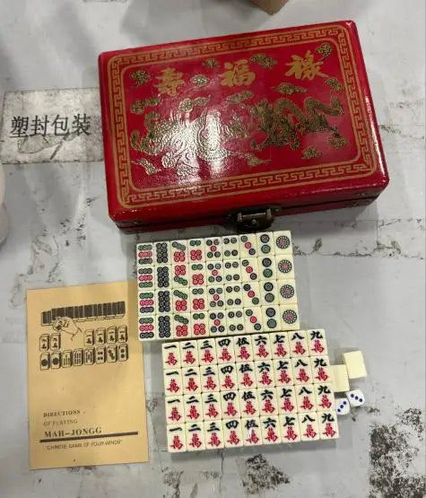 A red carrying case for a classic Chinese Mahjong set with 144 tiles and a separate set of tiles.