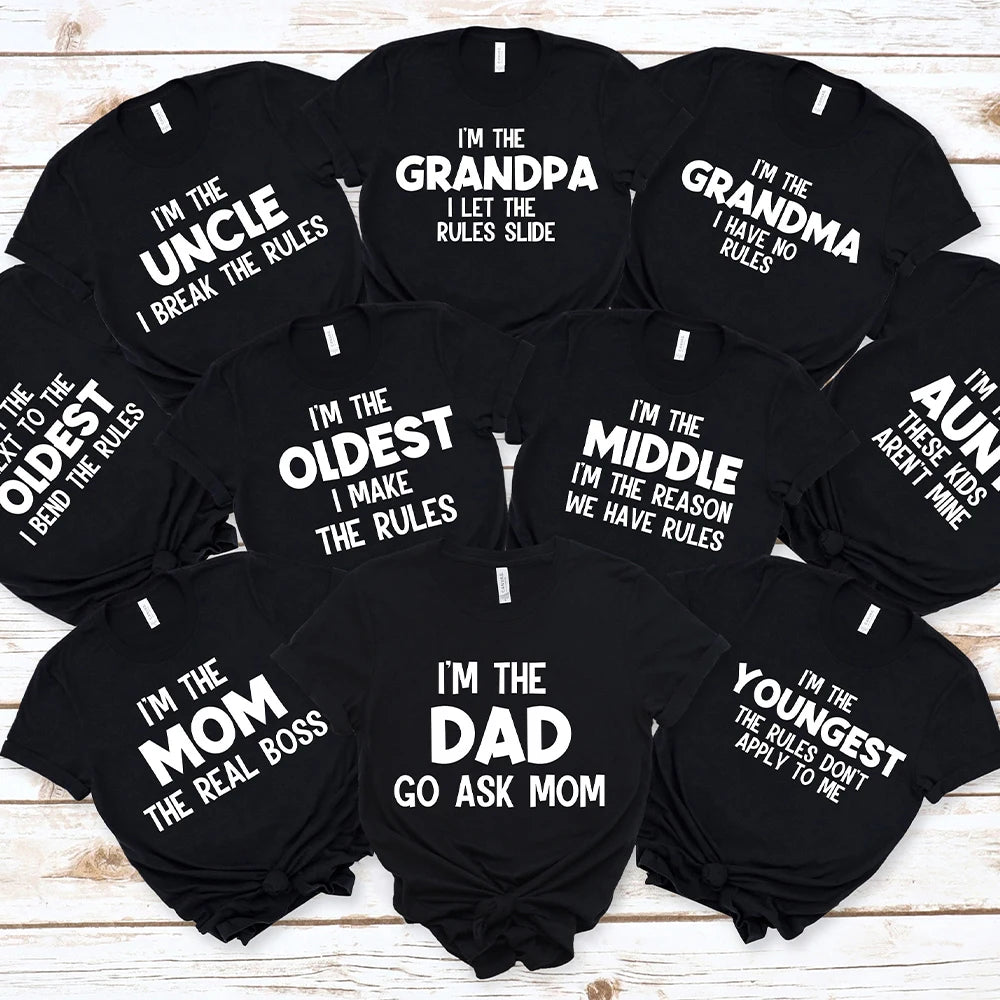 A set of black funny family matching t-shirts with text like I'm the grandpa, uncle, grandma, mom, dad, and youngest.