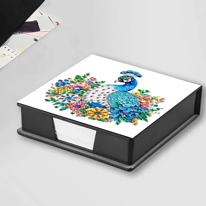 A flat, rectangular storage box featuring a diamond painting design of a peacock with colorful floral accents.