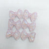 A collection of pink, iridescent mermaid-themed bowknot beads for jewelry making.