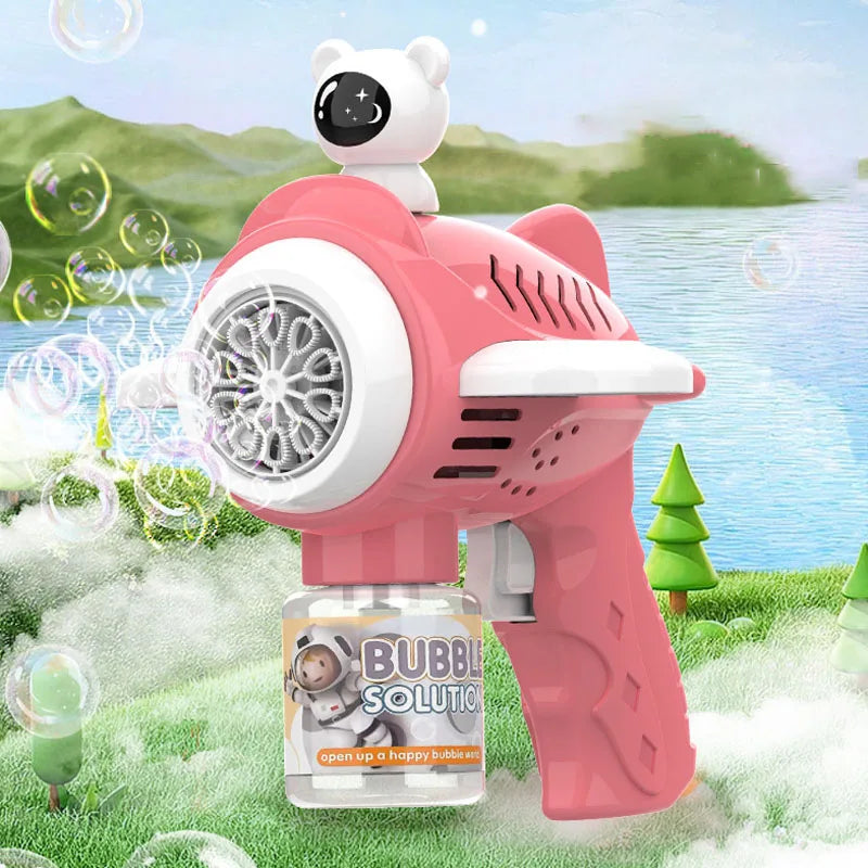 A pink bear-shaped automatic bubble gun is shown outdoors with green grass and water in the background.