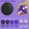 A hand holds a collection of purple and white magnetic sensory fidget balls with silicone shells.