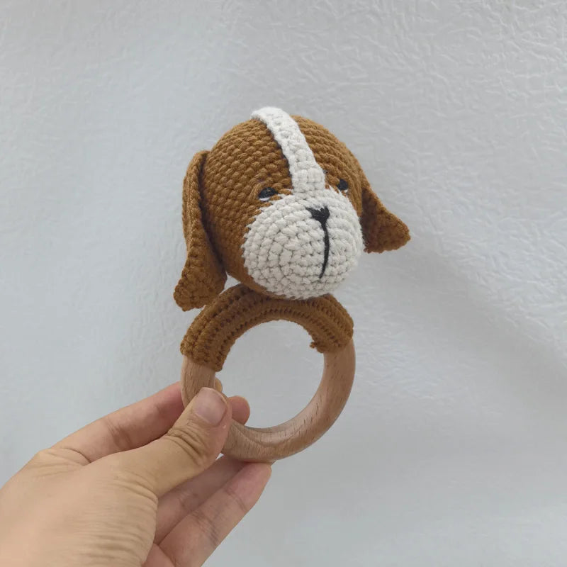A handcrafted wooden otter rattle and teether ring in brown and white colors.