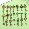 A collection of vintage brass key charms for jewelry making displayed on a light green surface.