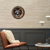 Aluminum wall art featuring a raccoon peering out of a tree hole mounted on a light beige wall.
