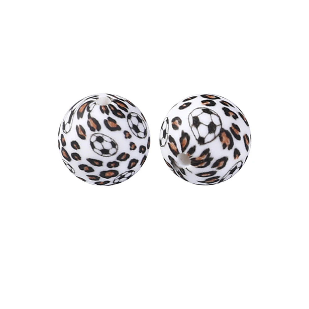 A pair of spherical silicone beads with a leopard print design and a soccer ball pattern.