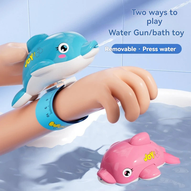 A hand is holding a blue dolphin shaped water gun, demonstrating two ways to play with the bath toy.