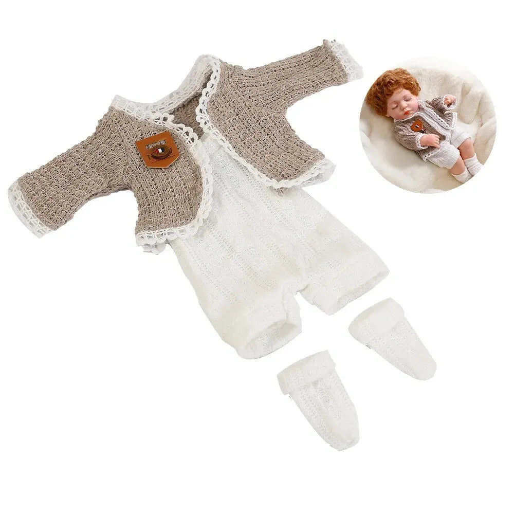 A knitted beige jumpsuit outfit for a 12-inch doll, including a matching bonnet and a baby doll.