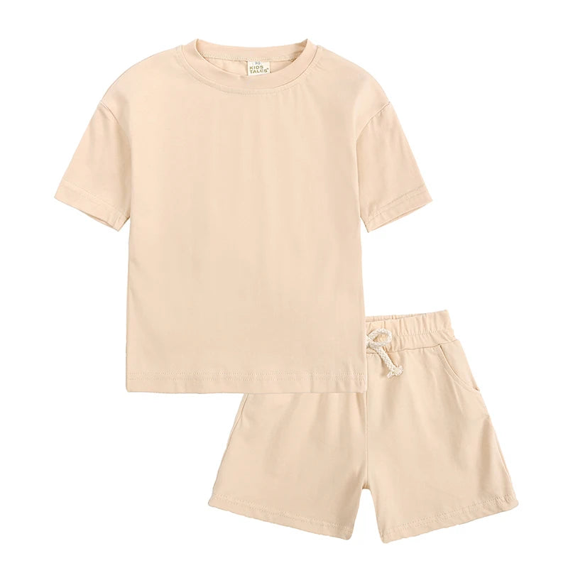 A light beige kids' summer tracksuit set featuring a short sleeve top and matching shorts.