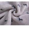A close-up of a white fleece jacket and pants set with small gray cartoon animal prints.