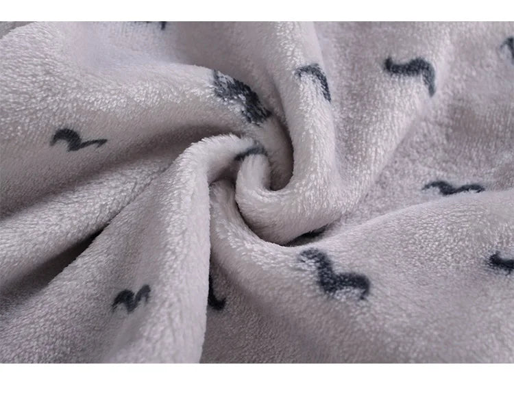 A close-up of a white fleece jacket and pants set with small gray cartoon animal prints.