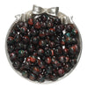 A small silver dish filled with dark reddish-brown and green glitter resin beads for jewelry making