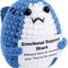 A blue and white crochet shark plush toy with a smiling expression.