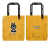 A pair of yellow paper shopping bags featuring a black illustration of a monster face and text.