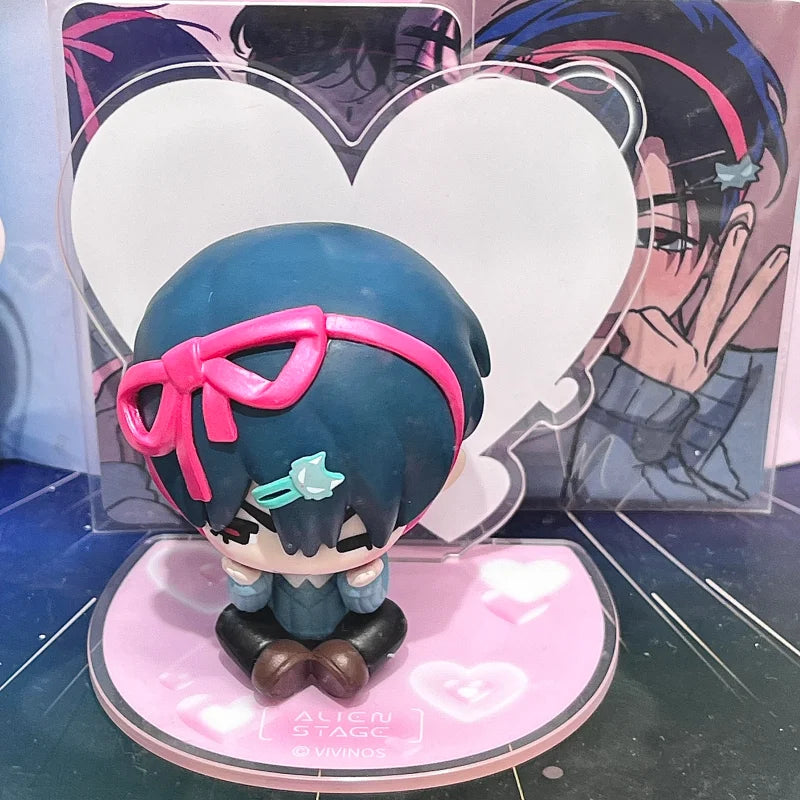 A blind box figure of a character with blue hair and pink accents displayed on a pink stand.