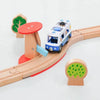 A wooden train track accessory set featuring a white and blue train on a curved track with wooden tree elements.