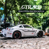 A white Nissan GTR R35 diecast model car is displayed outdoors on a gravel surface.