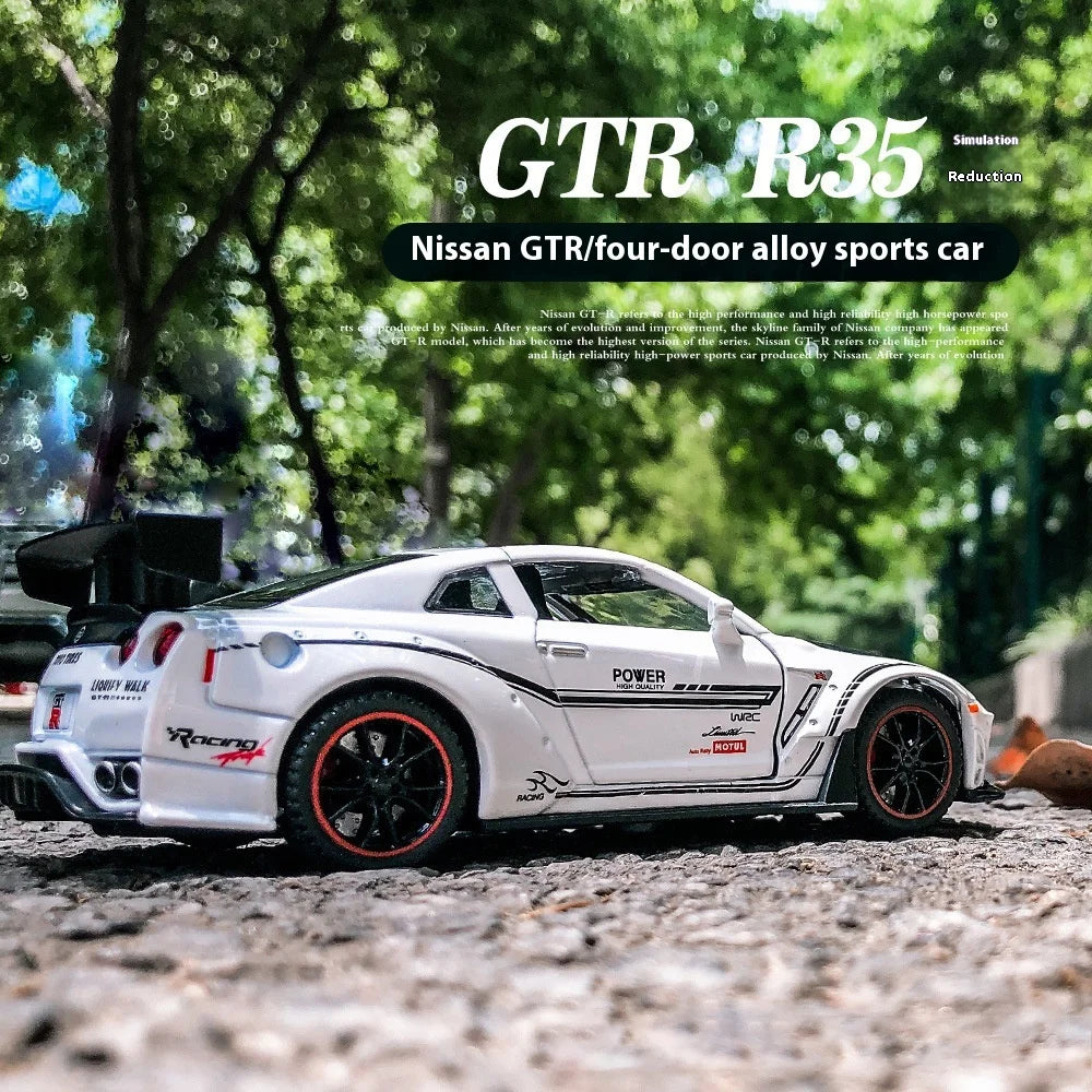 A white Nissan GTR R35 diecast model car is displayed outdoors on a gravel surface.