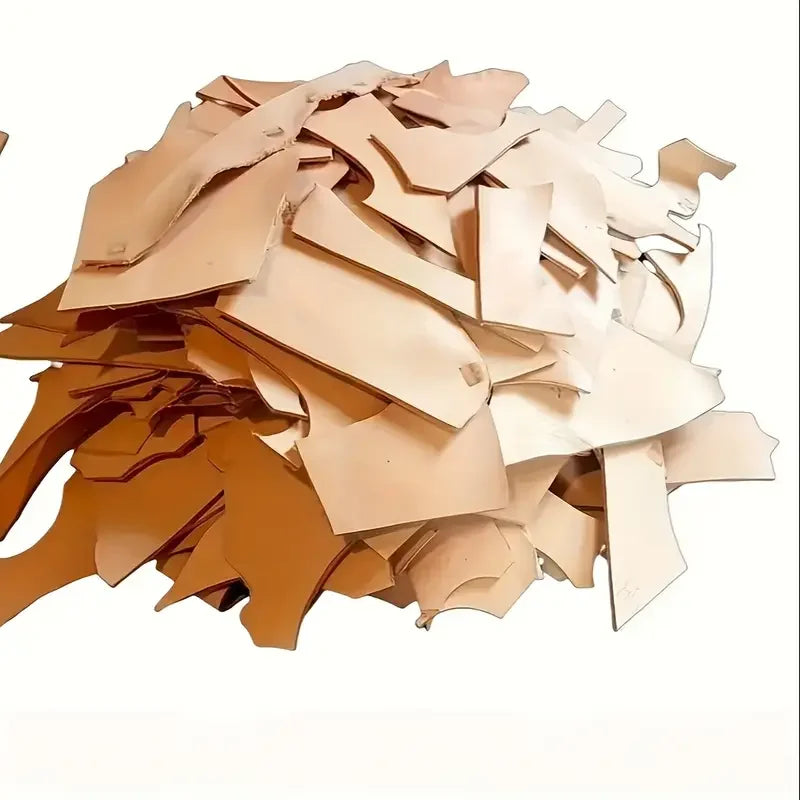 A pile of natural vegetable-tanned cowhide leather sheets for crafting in various shades of tan and brown.