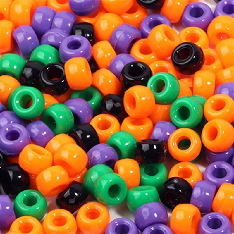 A large collection of colorful pony beads in various shades including orange, purple, green, and black.