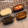 A collection of metal mechanical fidget sliders in various colors and designs resting on a gray laptop keyboard.