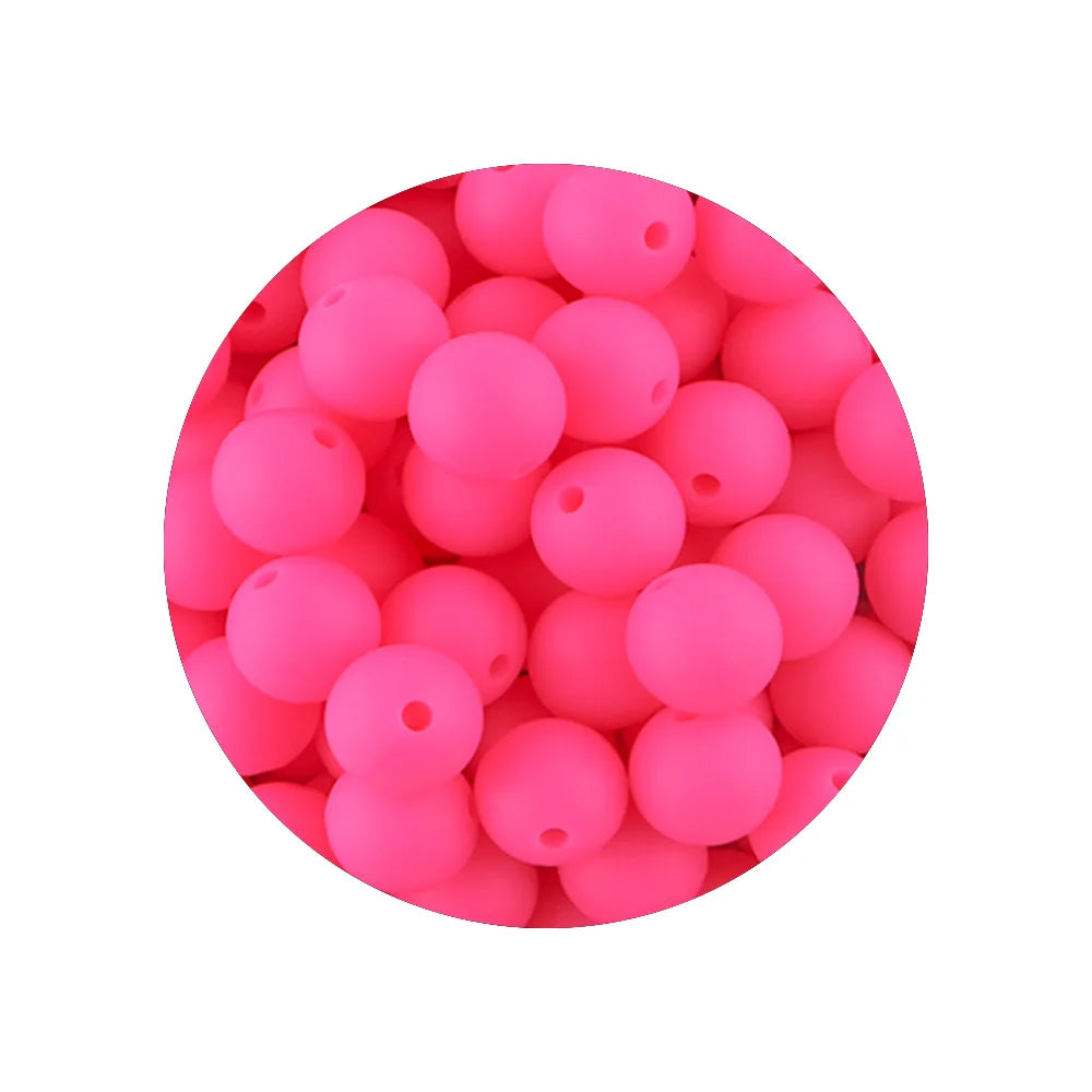 A circular arrangement of bright pink silicone beads in various sizes for DIY jewelry making.