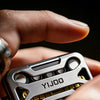 A hand holds a silver metal magnetic fidget slider with yellow accents, showing the YIJOO brand.