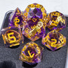A collection of purple resin dice with golden elven numbers, set against a dark surface.