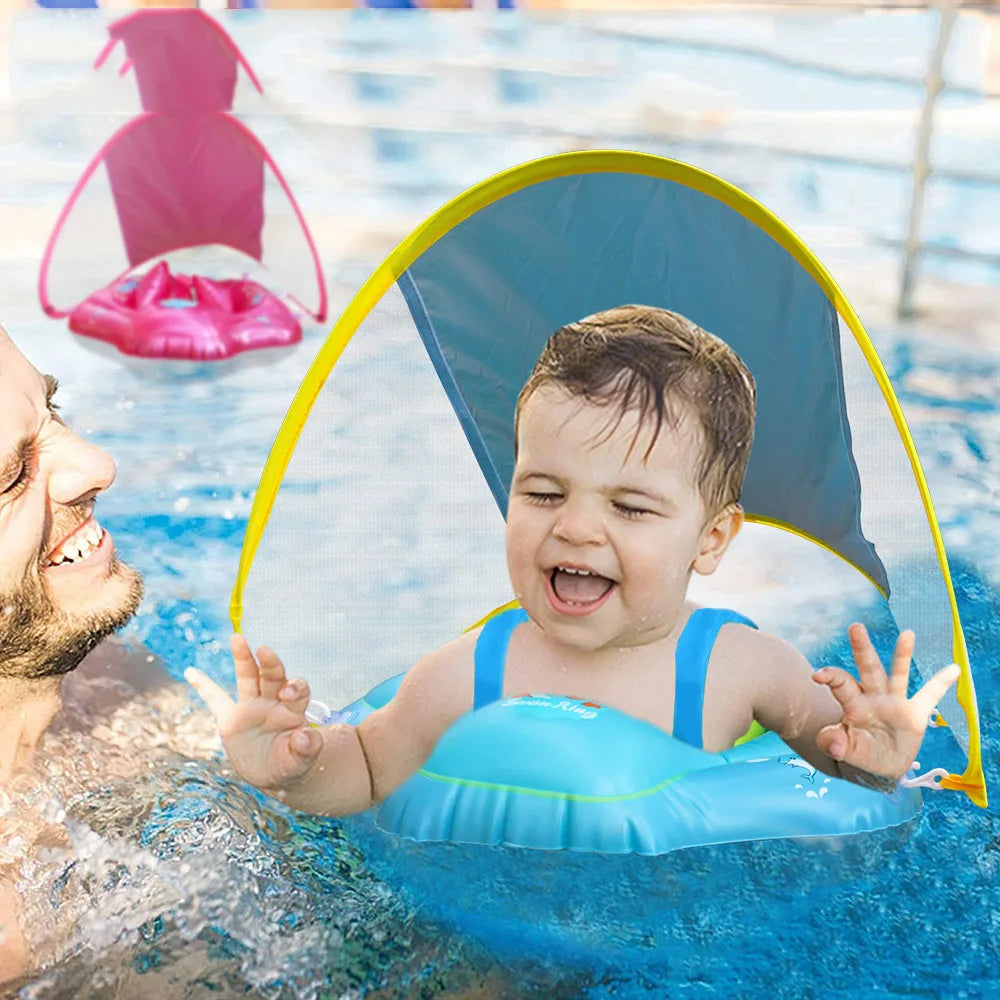 A baby is floating in water under a blue inflatable seat ring with a yellow sunshade canopy.